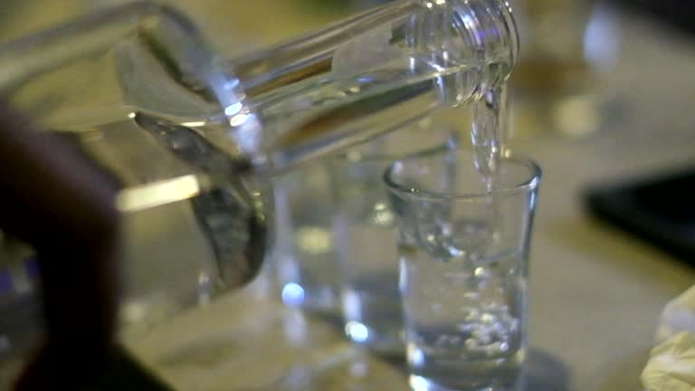 Pouring vodka into a glass, highlighting its unexpected cleaning uses discussed in the article.